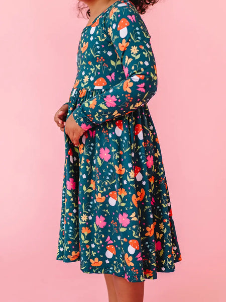 Person wearing a floral dress with a pink background