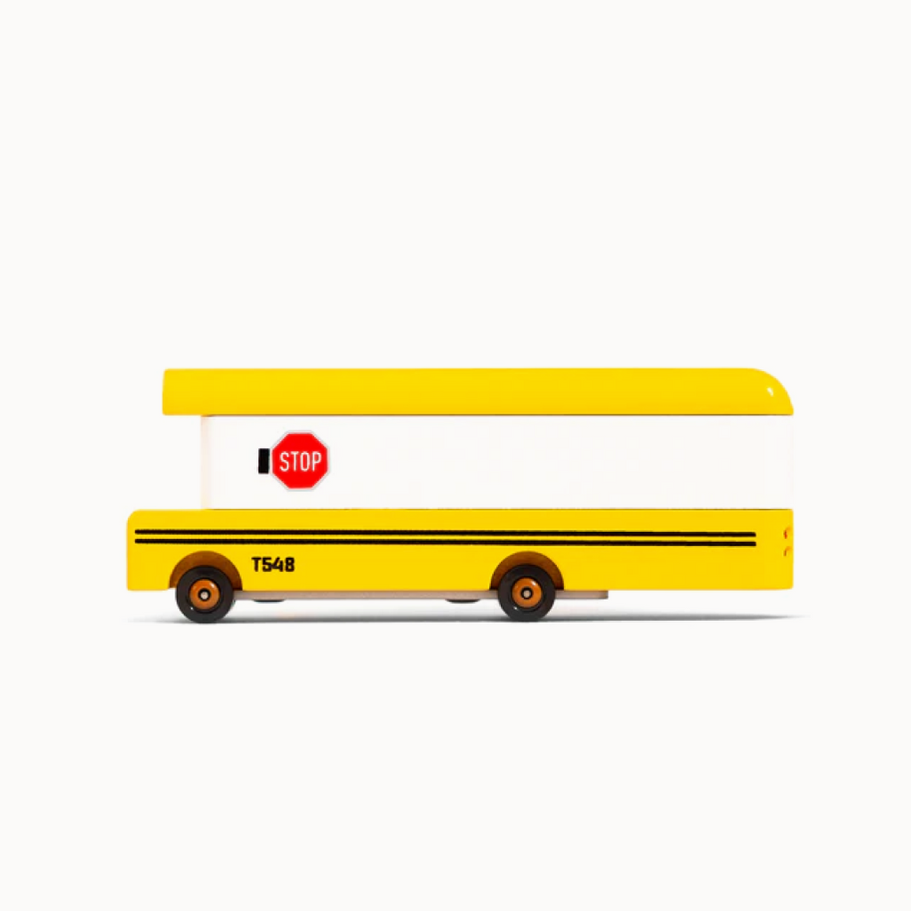 Yellow toy school bus with a stop sign on a white background