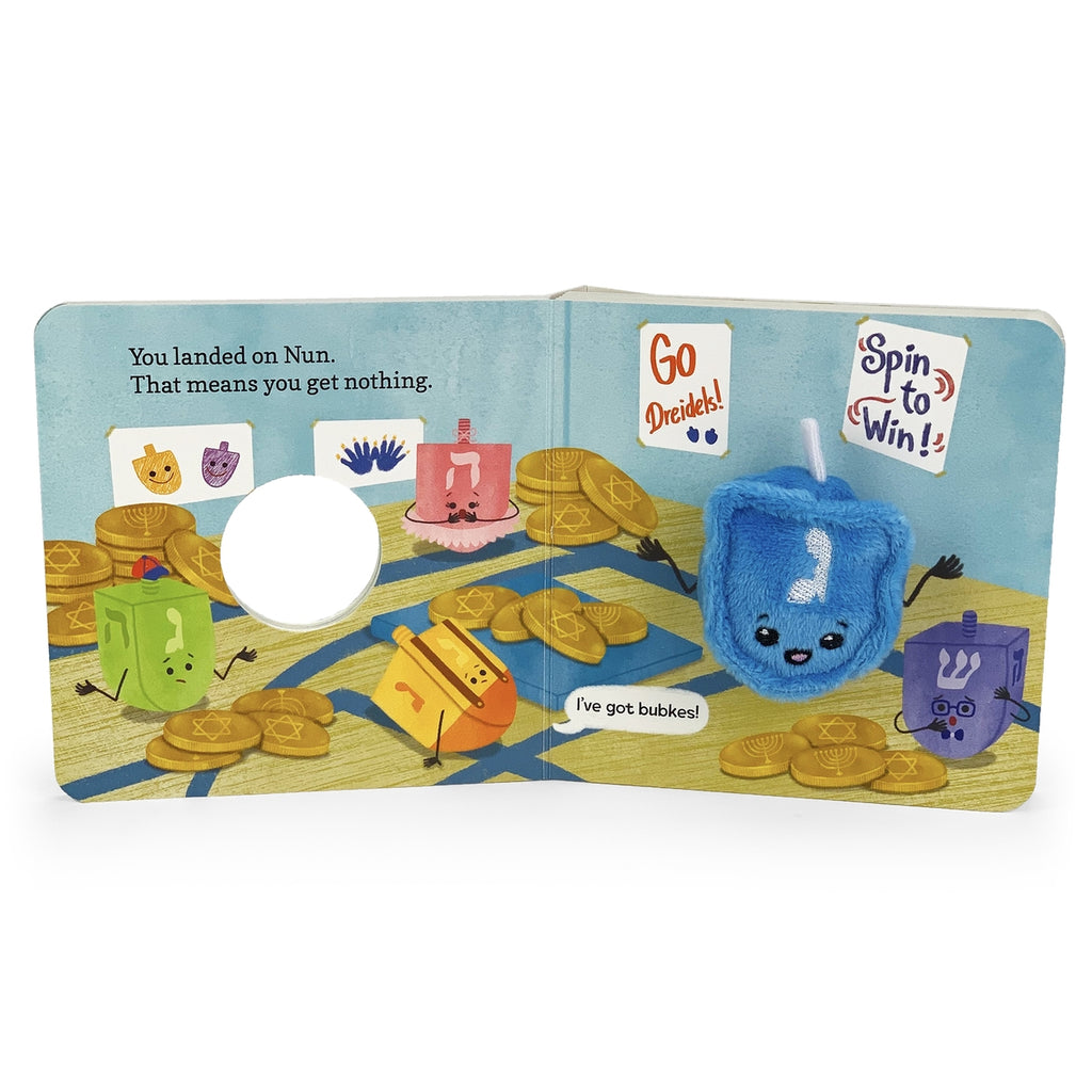Children's book with a colorful illustration of a dreidel game and cartoon characters on a white background.