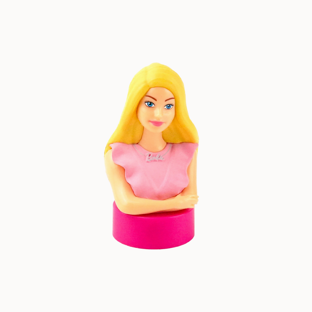 Toy figure of a girl with blonde hair and pink dress on a white background