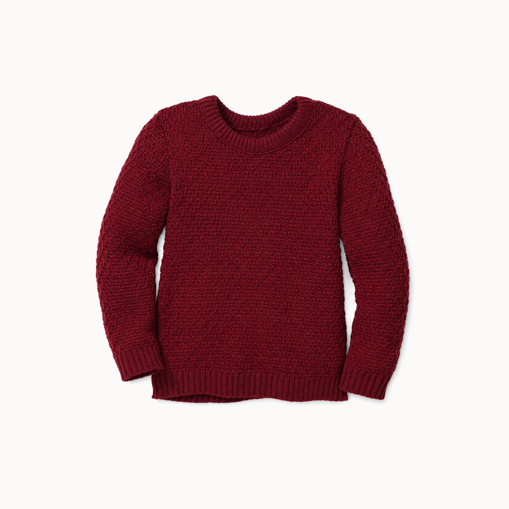 A maroon, crew neck, long-sleeved pullover sweater with a traditional zigzag pattern.