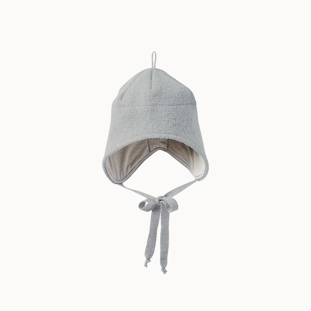 A light gray knit baby bonnet hat with ear flaps and a chin tie, shown against a plain off-white background.