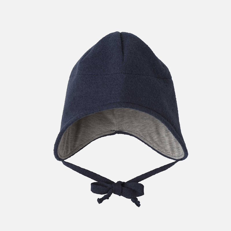 Navy blue baby bonnet with gray interior on a light gray background