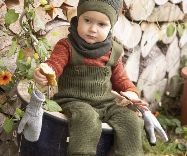 child wearing knitted wool clothing against a stone background