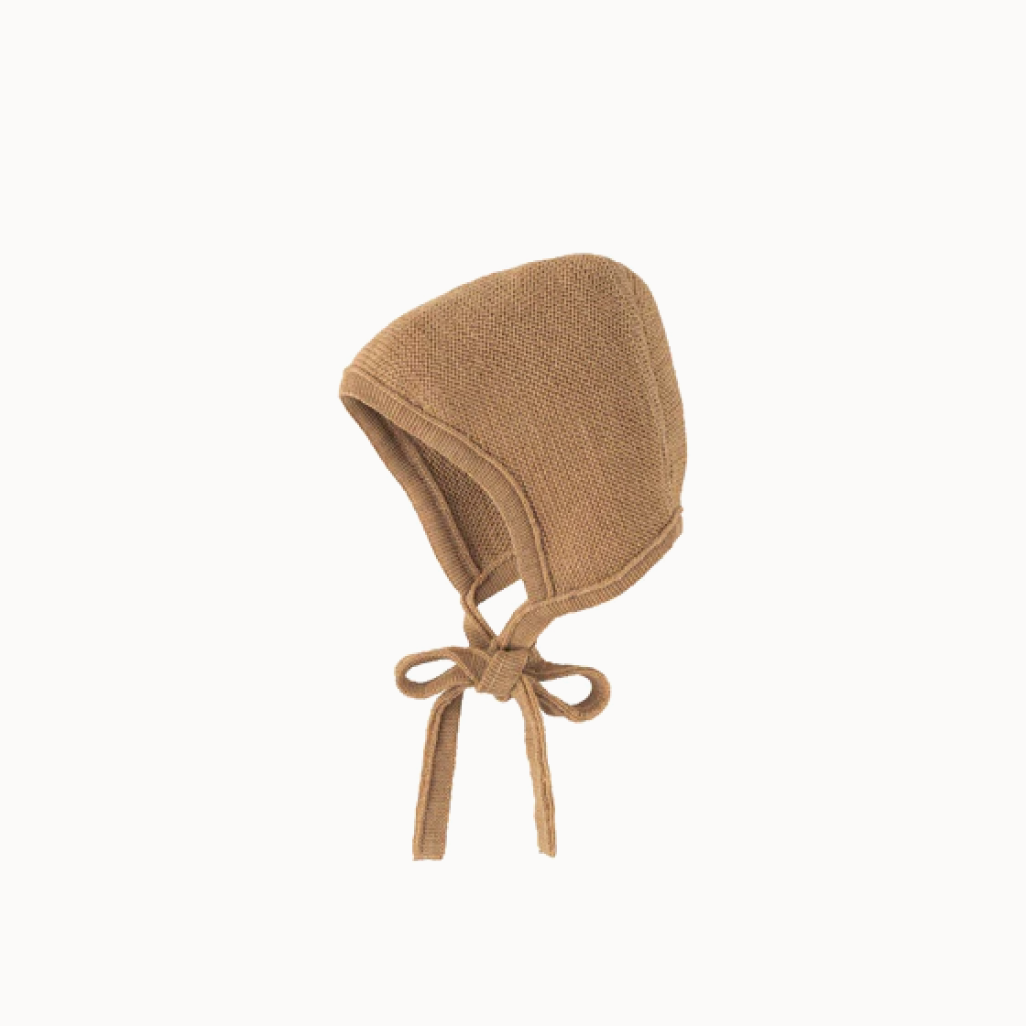 Caramel-colored knitted bonnet for baby, tied at the bottom with a bow