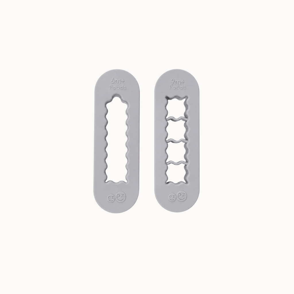 Two gray silicone food cutters designed for baby-led weaning, one for creating finger-length strips and the other for bite-sized cubes.