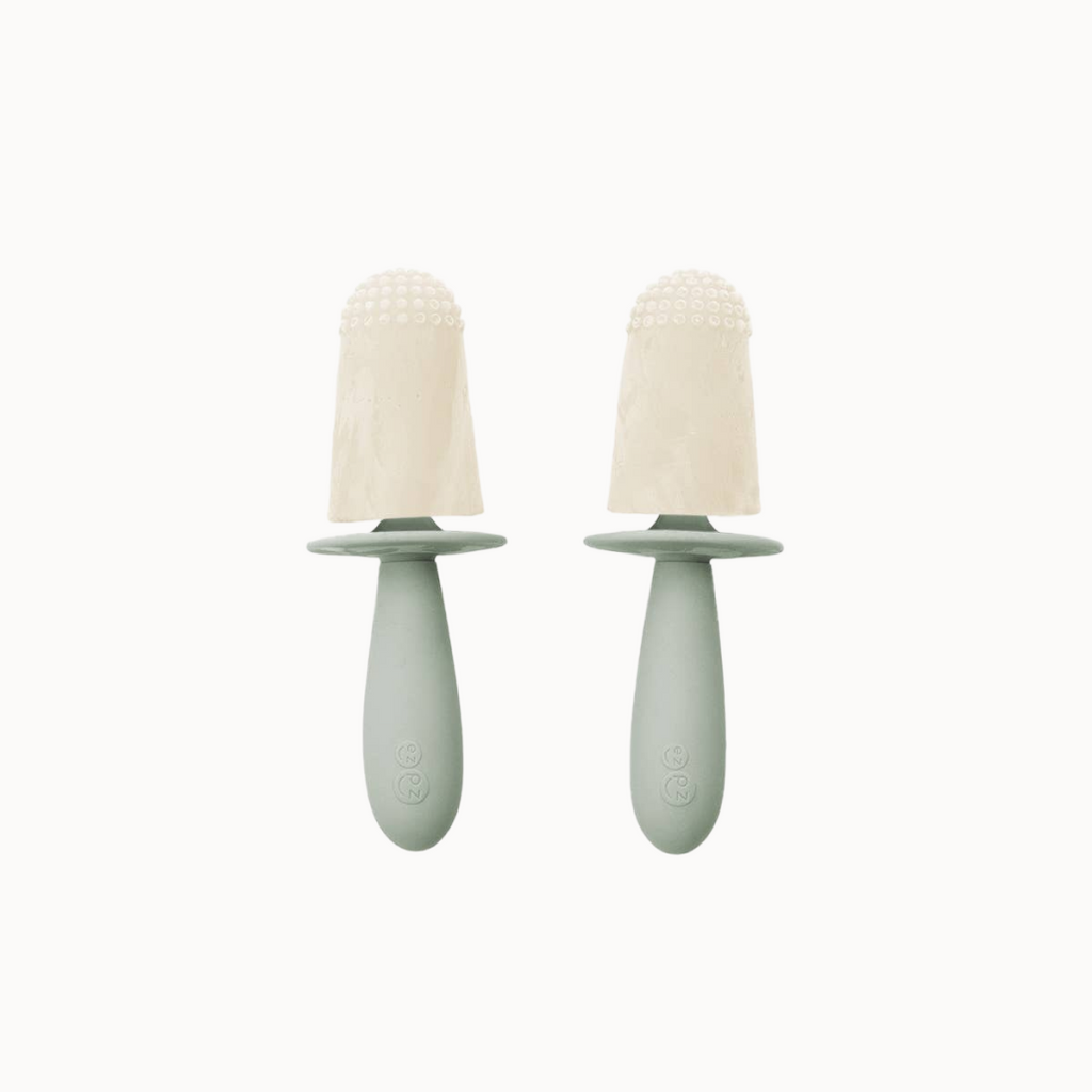Two green baby soothers with beige silicone teats on a white background