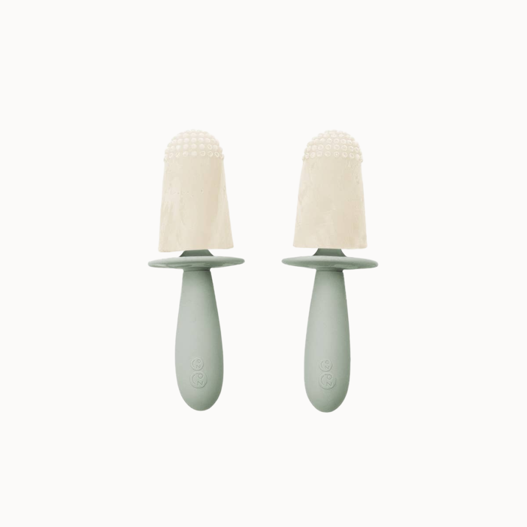 Two green baby soothers with beige silicone teats on a white background