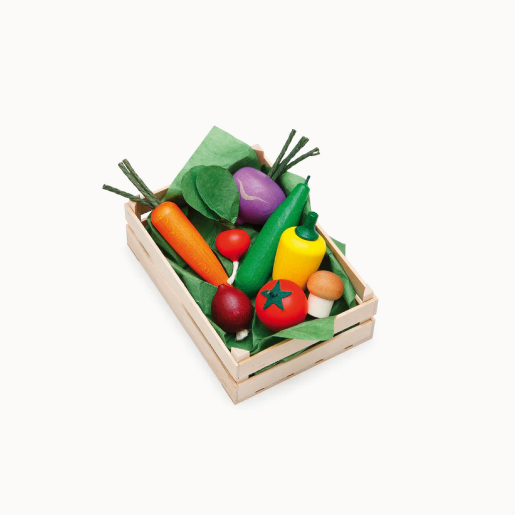 Set of colorful toy vegetables in a wooden crate on a white background