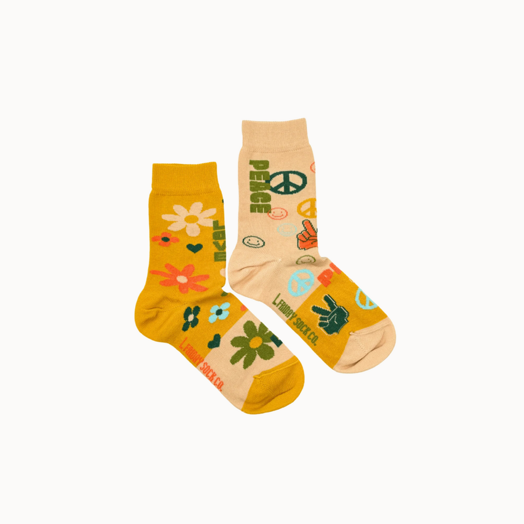 Two pairs of socks with peace signs and floral designs on a white background.