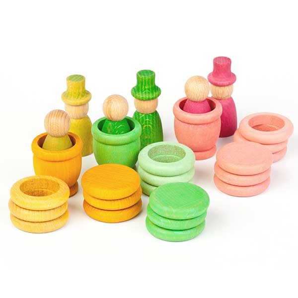 Colorful wooden toys including stacked rings and small figures on a white background