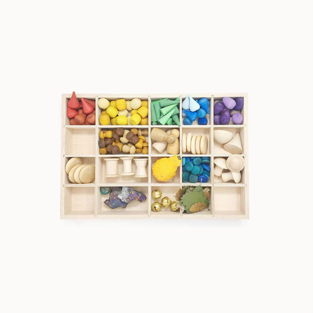 Wooden toy sorting box with various colored wooden shapes on a white background