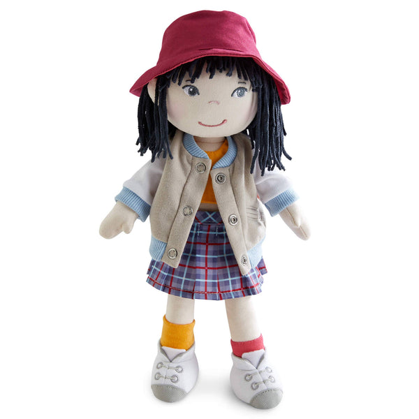 Stuffed doll with a red hat, beige jacket, plaid skirt, and orange socks on a white background