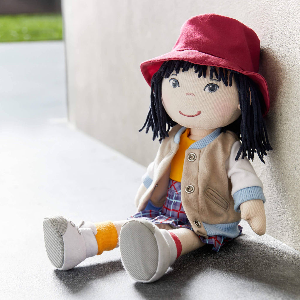 Plush toy with a red hat and colorful outfit sitting on a surface.