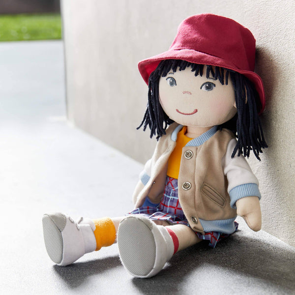 Plush toy with a red hat and colorful outfit sitting on a surface.