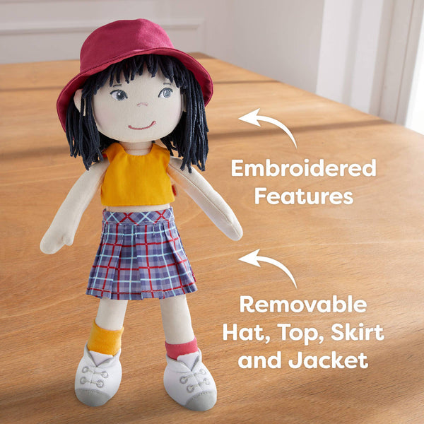 Doll with embroidered features and removable clothing on a wooden surface