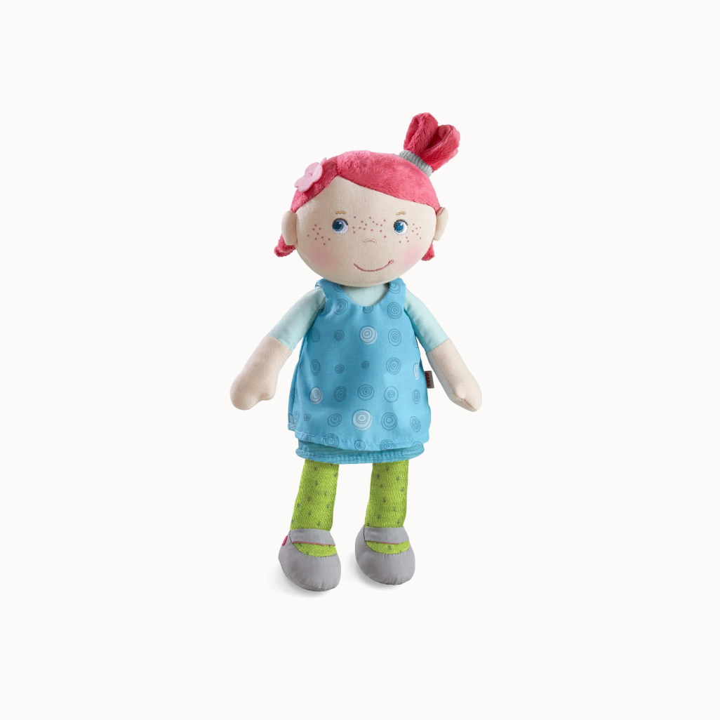 Plush toy with pink hair, blue dress, and green pants on a white background