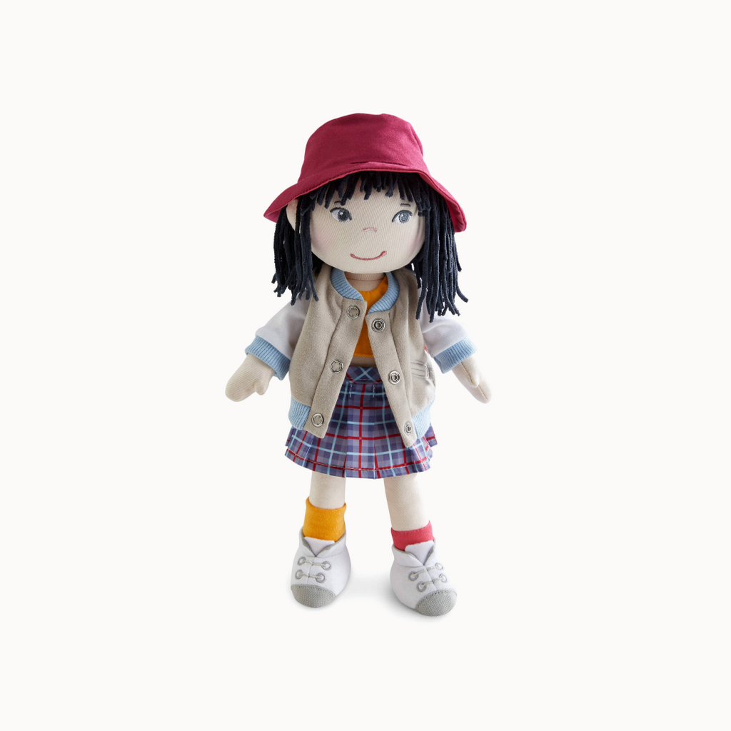Stuffed doll with a red hat, beige jacket, plaid skirt, and orange socks on a white background