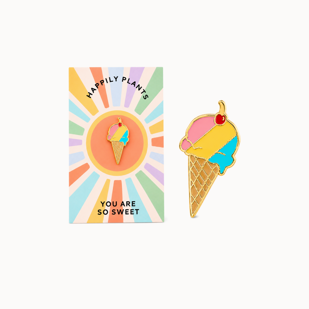 Ice cream cone-shaped pendant with a cherry on top, displayed in front of a colorful card.