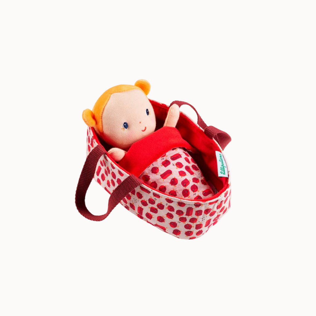 Toy doll in a red polka dot bag on a white background