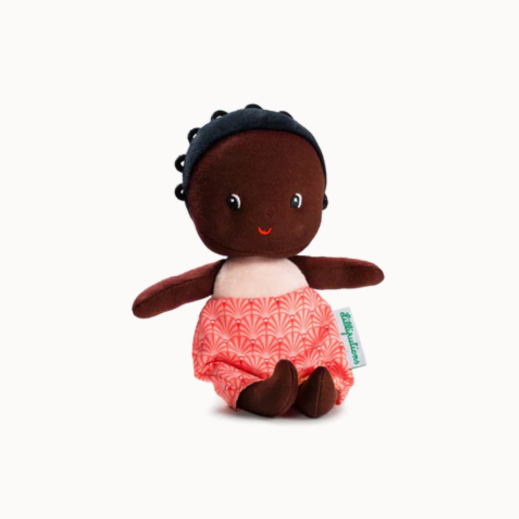 Stuffed toy with dark skin, black hair, and red patterned pants on a white background