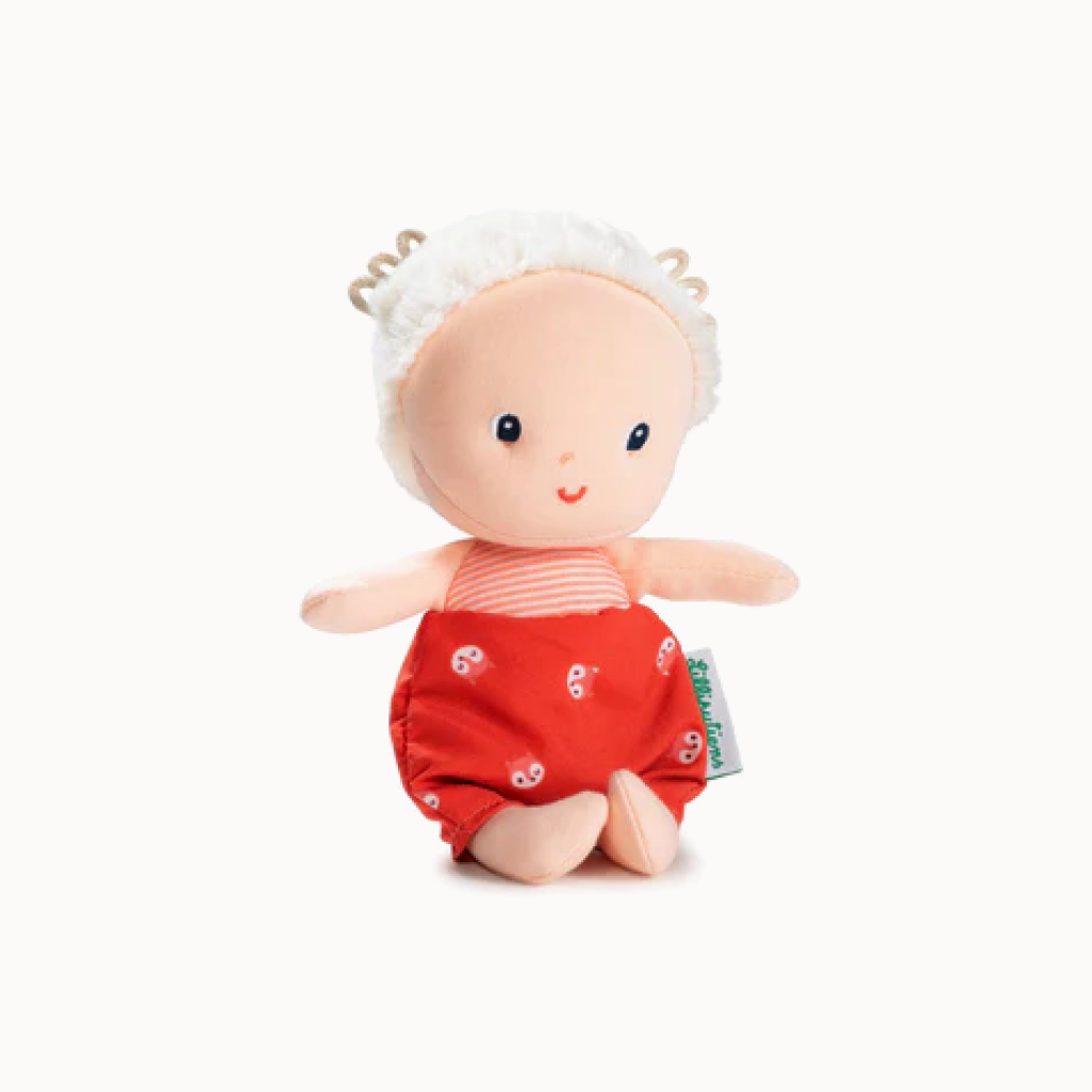 Stuffed doll with red outfit and white headband on a white background