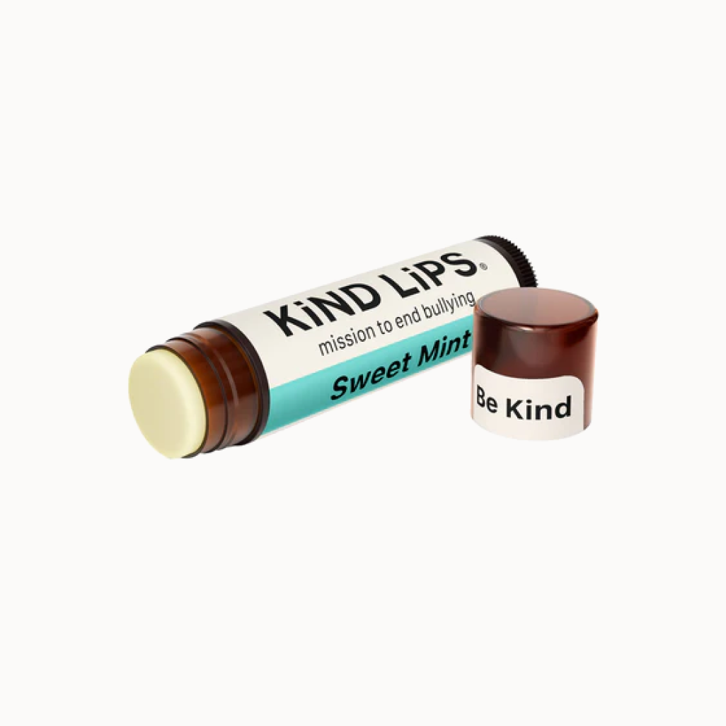Lip balm with 'Kind Lips' packaging on a white background