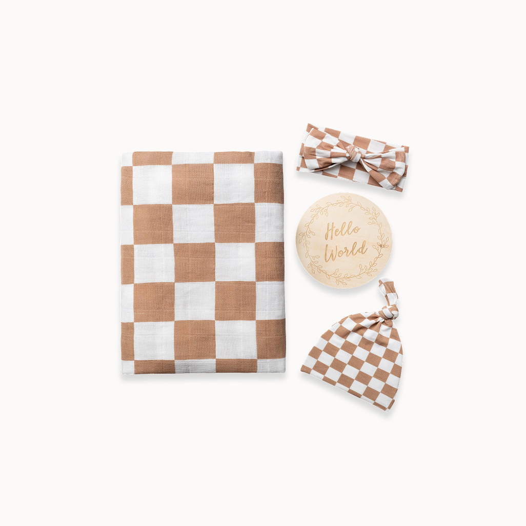 Checkered baby blanket, headband, and hat with 'Hello World' wooden disc on a white background