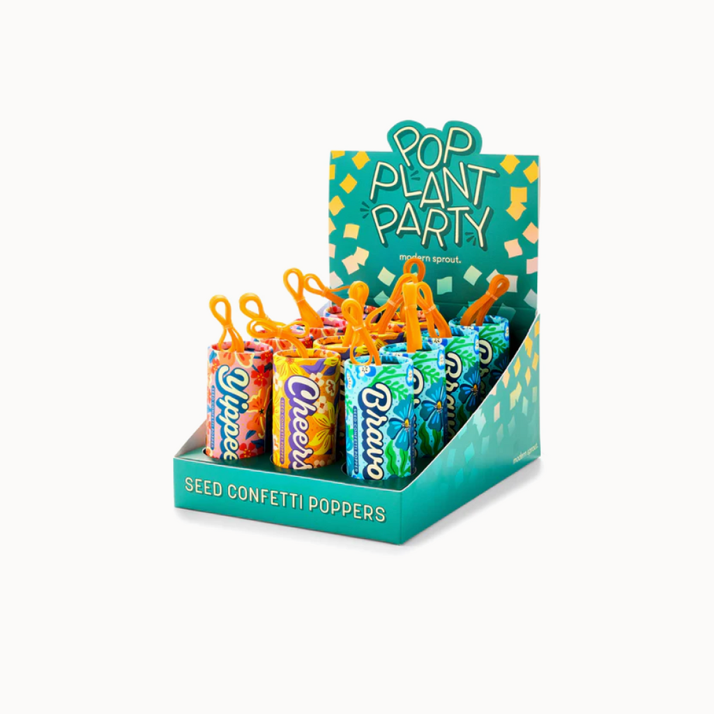 Display of 'Pop Plant Party' seed confetti poppers with colorful packaging and orange plant figures.