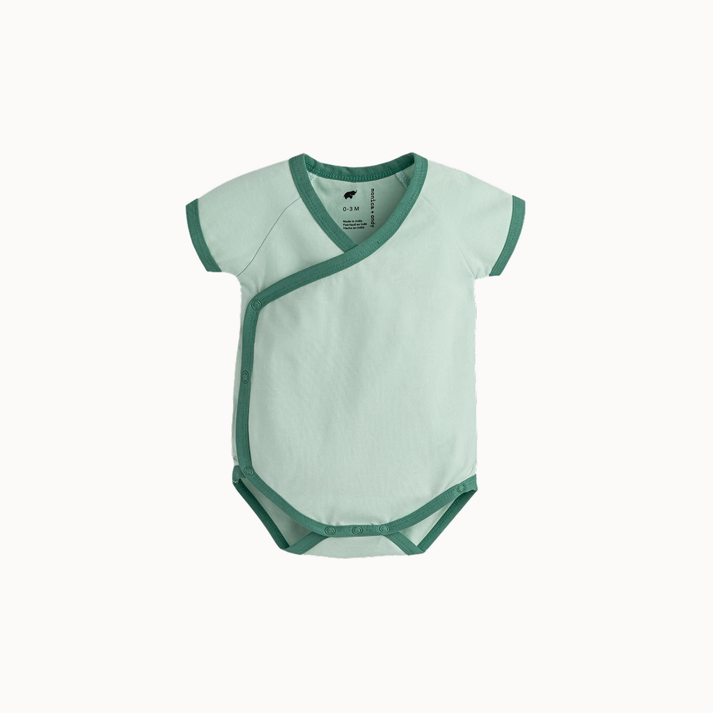 Green baby bodysuit with green trim on a white background