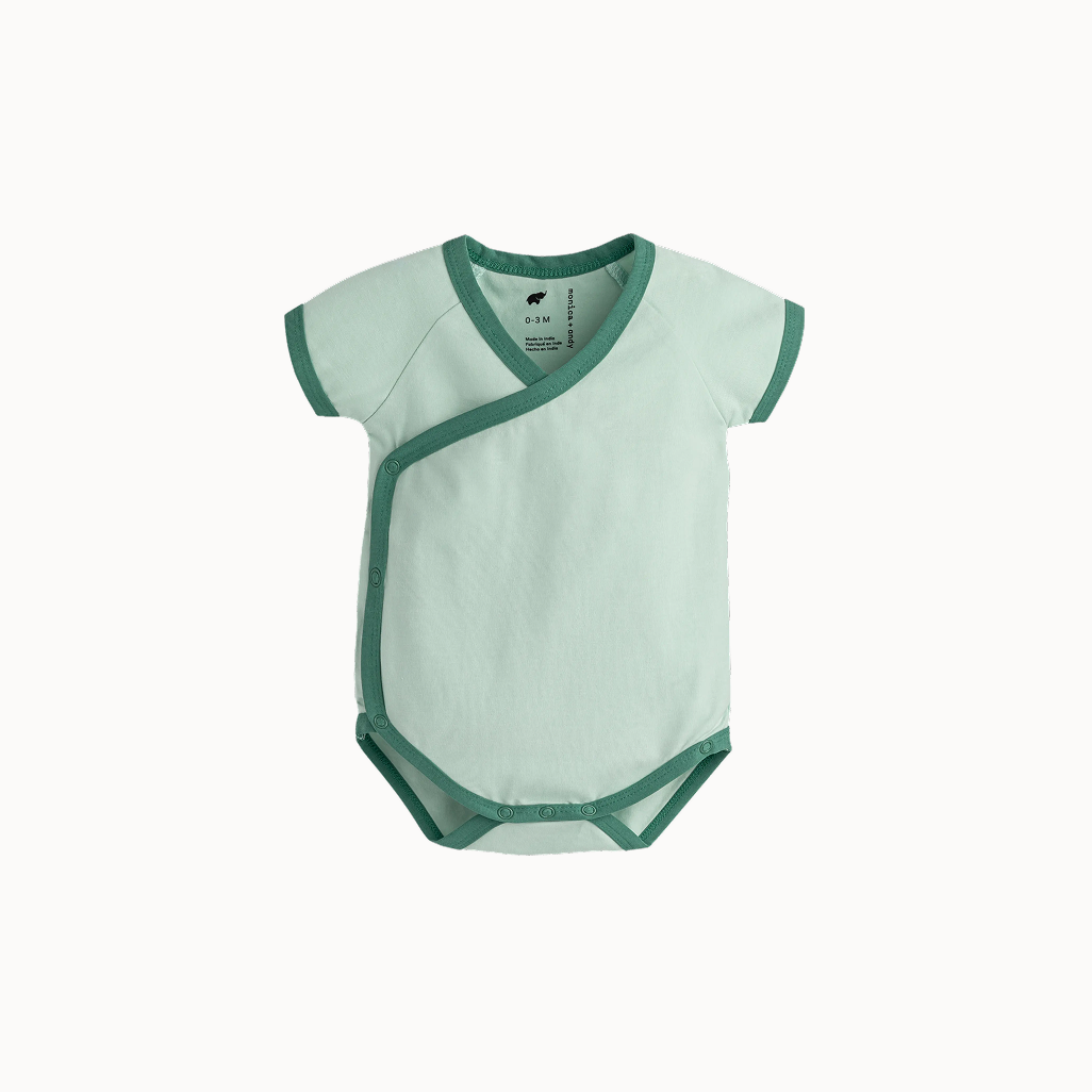 Green baby bodysuit with green trim on a white background
