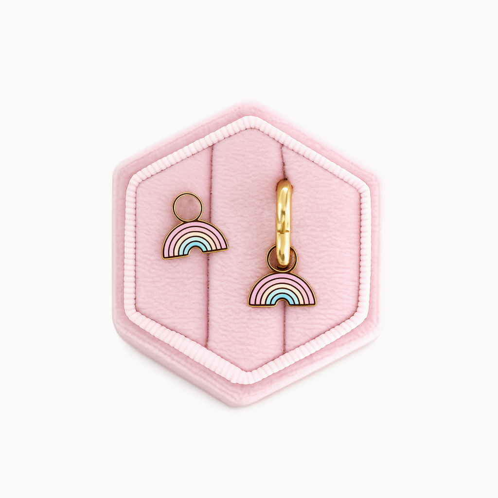 Rainbow-shaped earrings on a pink hexagonal jewelry box