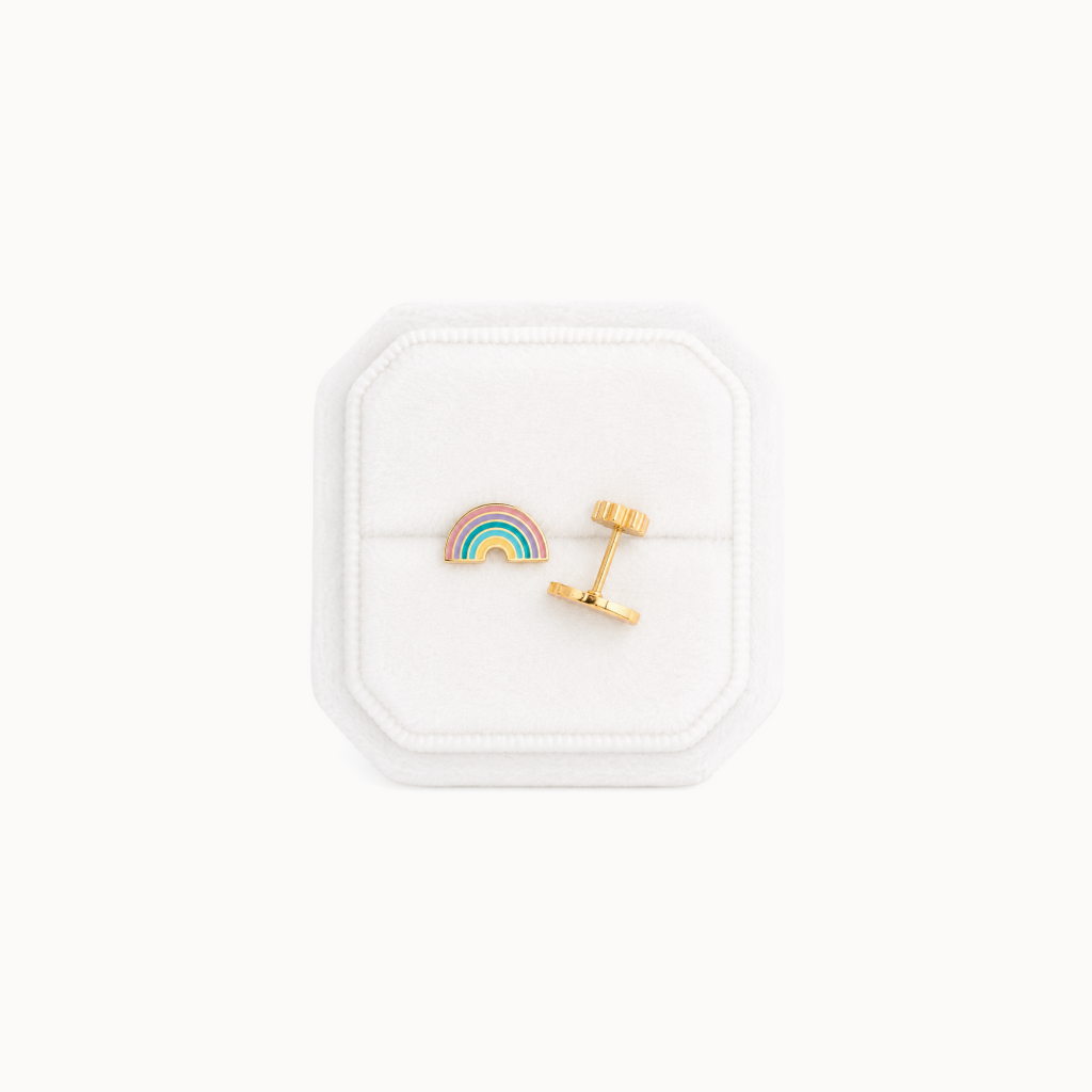Rainbow-shaped earrings in a white jewelry box on a white background