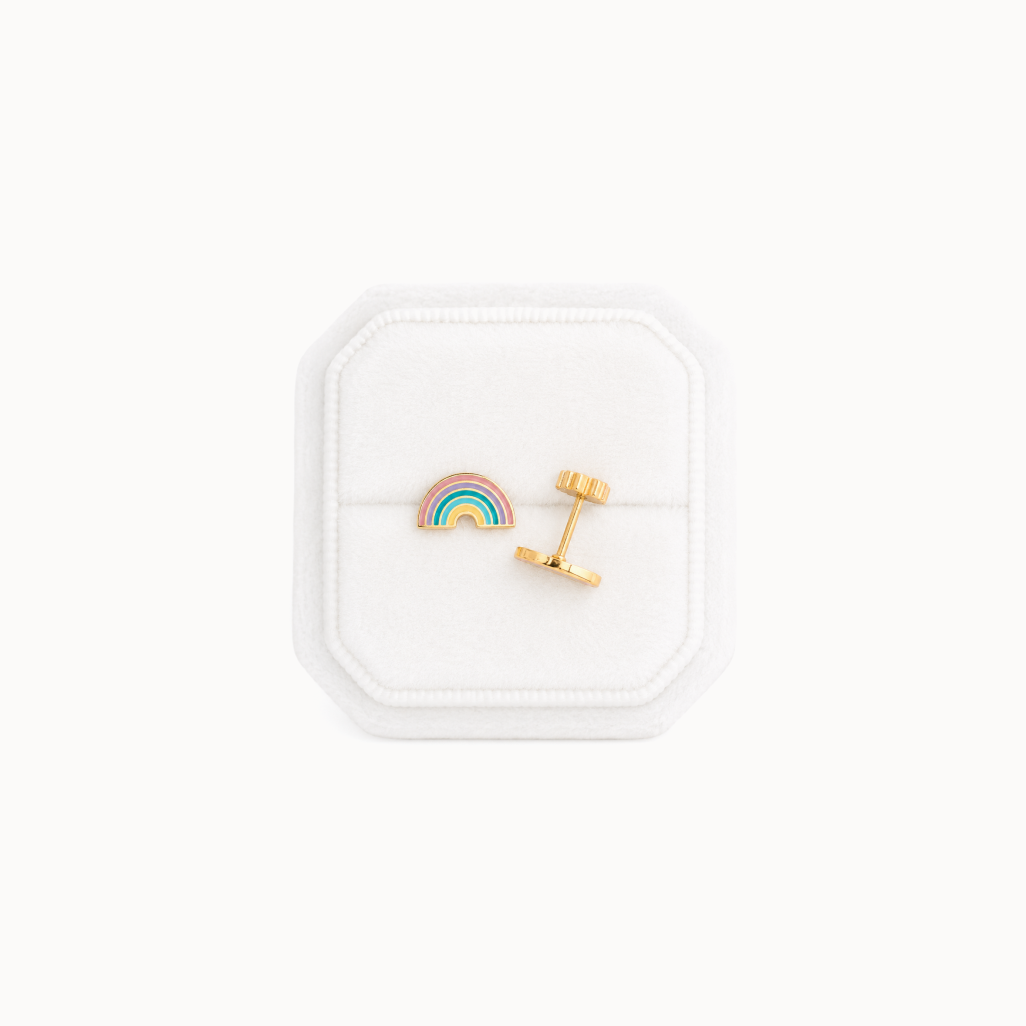 Rainbow-shaped earrings in a white jewelry box on a white background