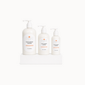 Three bottles of unscented face and body lotion on a white surface