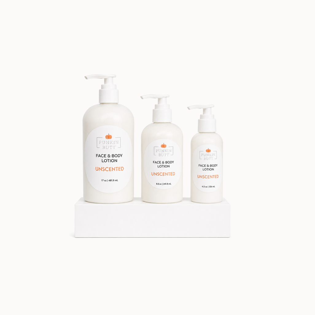 Three bottles of unscented face and body lotion on a white surface