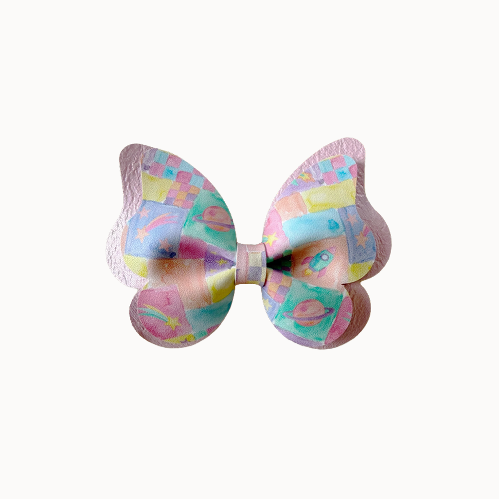 butterfly hair bow with pastel illustrations print on a white background