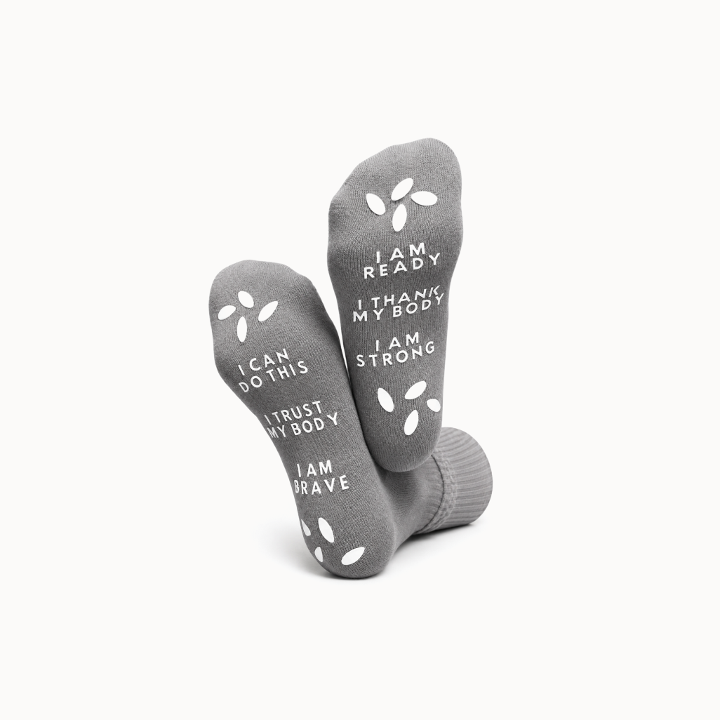 Gray socks with motivational text on a white background