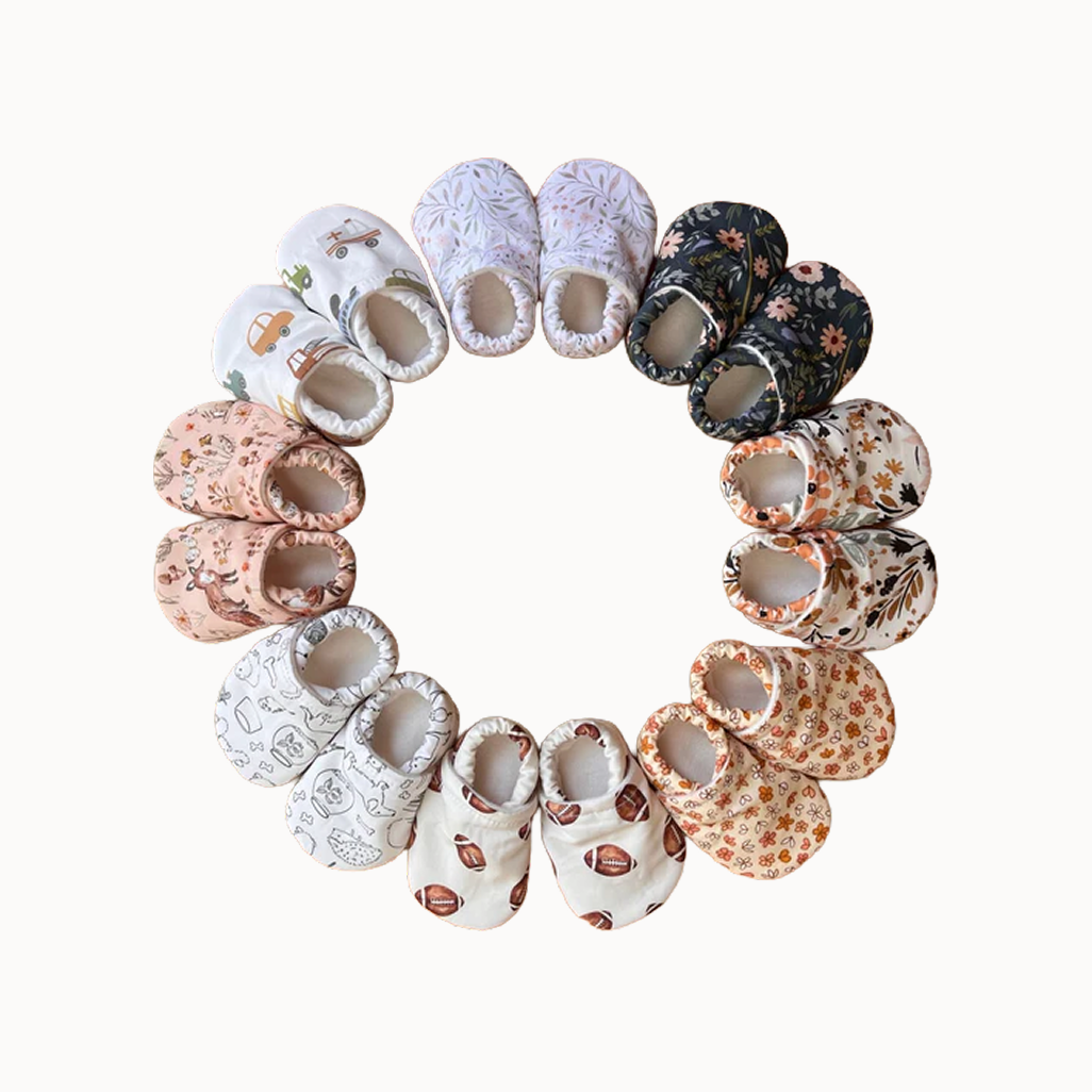 Assorted baby shoes arranged in a circular pattern on a white background