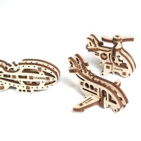 Three wooden mechanical models on a white background, branded 'Ugears'.