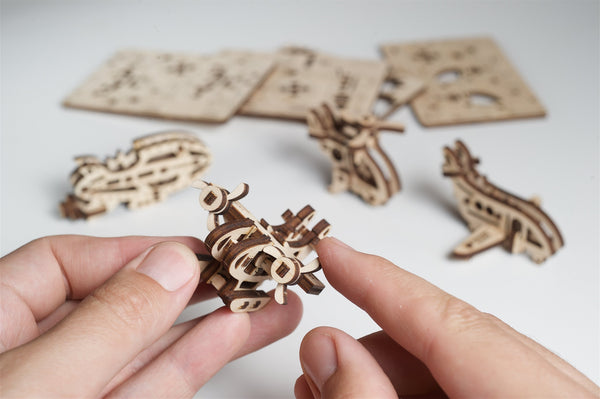 Wooden puzzle pieces being held by a hand with a white background