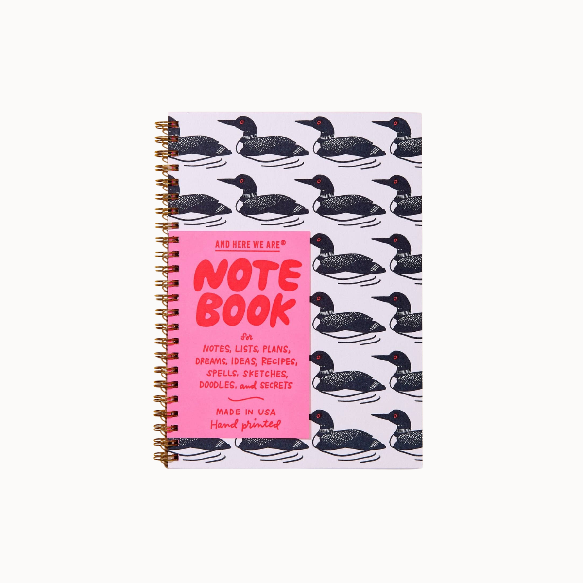 A spiral-bound notebook with a pink front cover and a light lavender cover patterned with black-and-white loon ducks, shown on a plain light background.