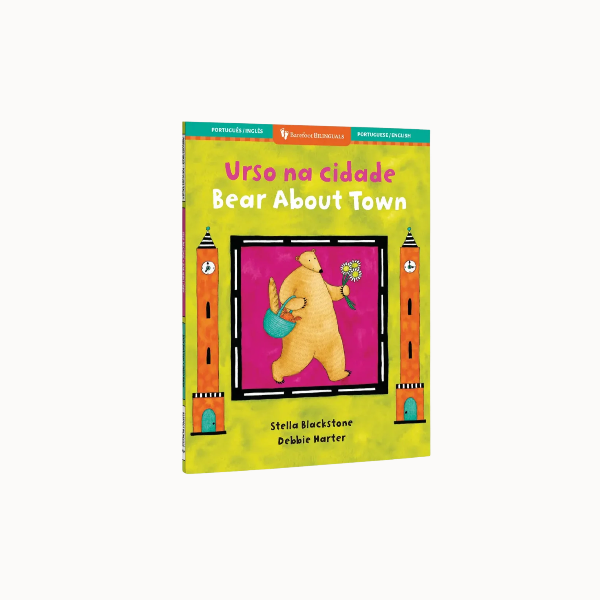 Children's book titled 'Urso na cidade / Bear About Town' shown upright on a plain light gray background. The cover is bright yellow-green with a central illustration of a bear holding a blue bucket and flower, framed by orange clock towers on a magenta panel.