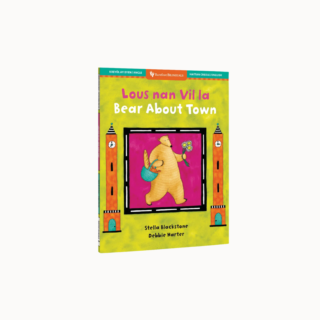 Children's picture book titled "Laus nan Villa Bear About Town" shown upright on a light gray background. The cover is bright yellow-green with a central illustration of a bear holding a blue bucket and pink flower, framed by orange tower-like shapes.