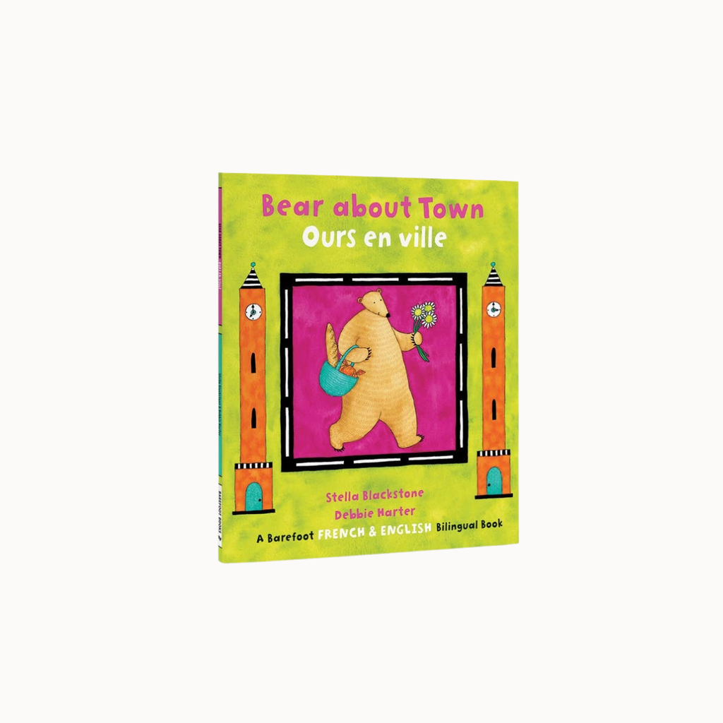 A children's bilingual book titled 'Bear about Town / Ours en ville' shown upright on a plain white background. The cover is bright yellow-green with an illustration of a bear holding a flower and a blue bag, framed by two orange tower-like figures.