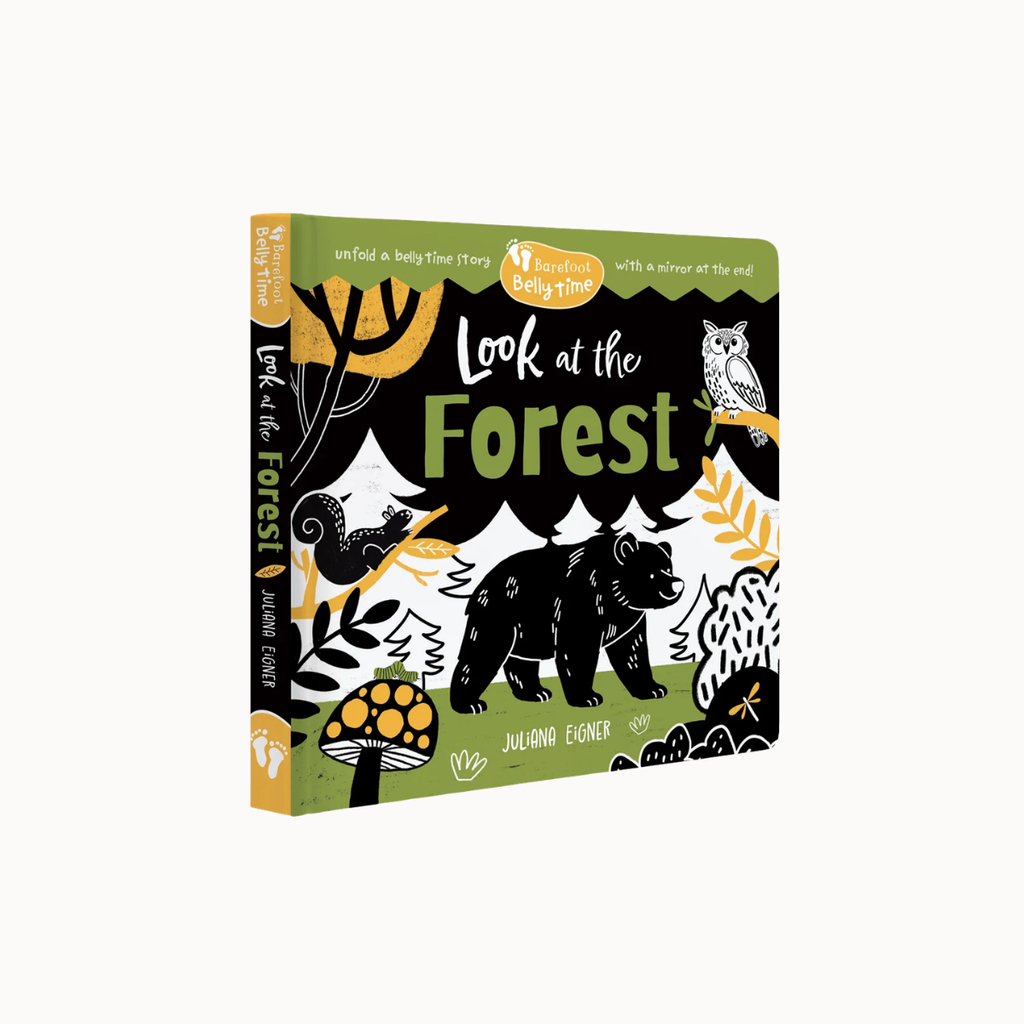 A children's hardcover book titled "Look at the Forest" by Ingrid Eiger, shown at a three-quarter angle on a plain white background. The cover features a black background with forest illustrations in green, yellow, white, and black, including a bear, owl, mushroom, and trees.