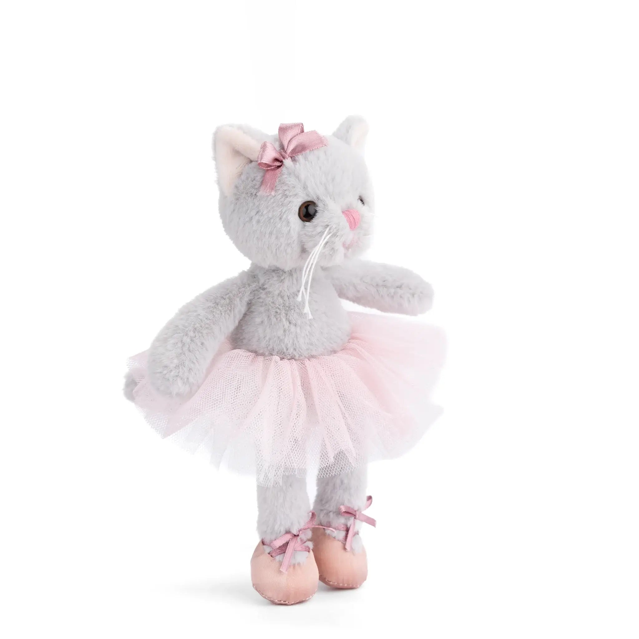 A plush gray cat toy dressed as a ballerina, wearing a pink tutu skirt, pink bow on the head, and pink ballet shoes, photographed on a clean white background.