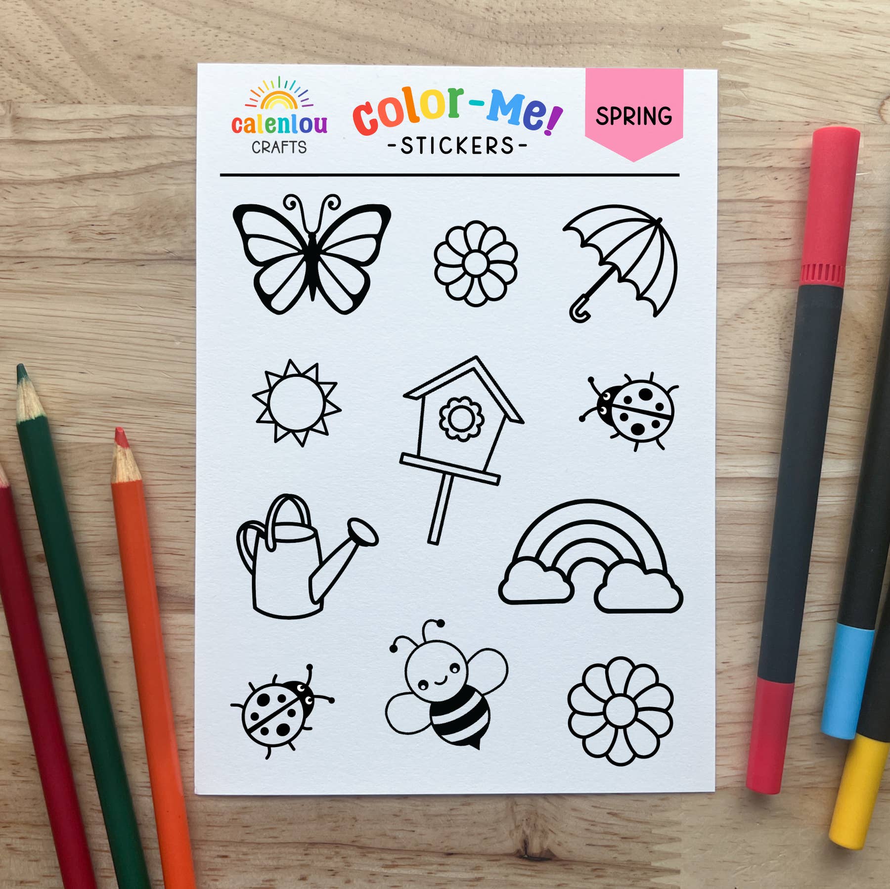 Sheet of spring-themed stickers with coloring tools on a wooden surface