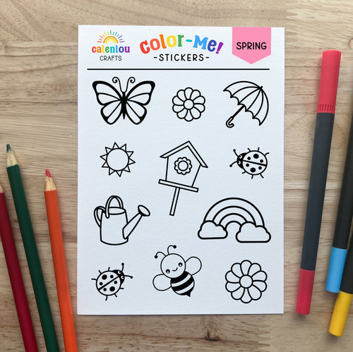Sheet of spring-themed stickers with coloring tools on a wooden surface