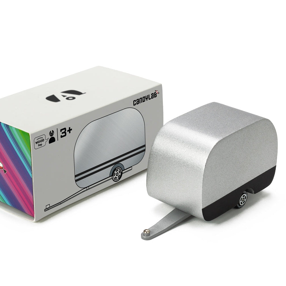 Silver airstream camper toy device with colorful packaging on a white background
